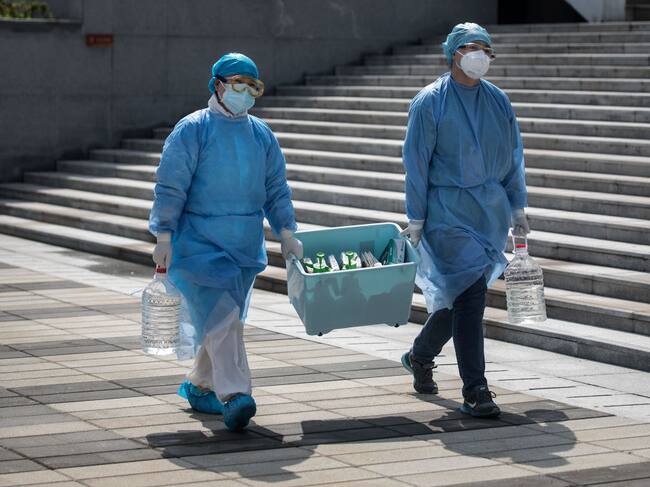 Funcionarios médicos transportan muestras del Covid-19 en Wuhan