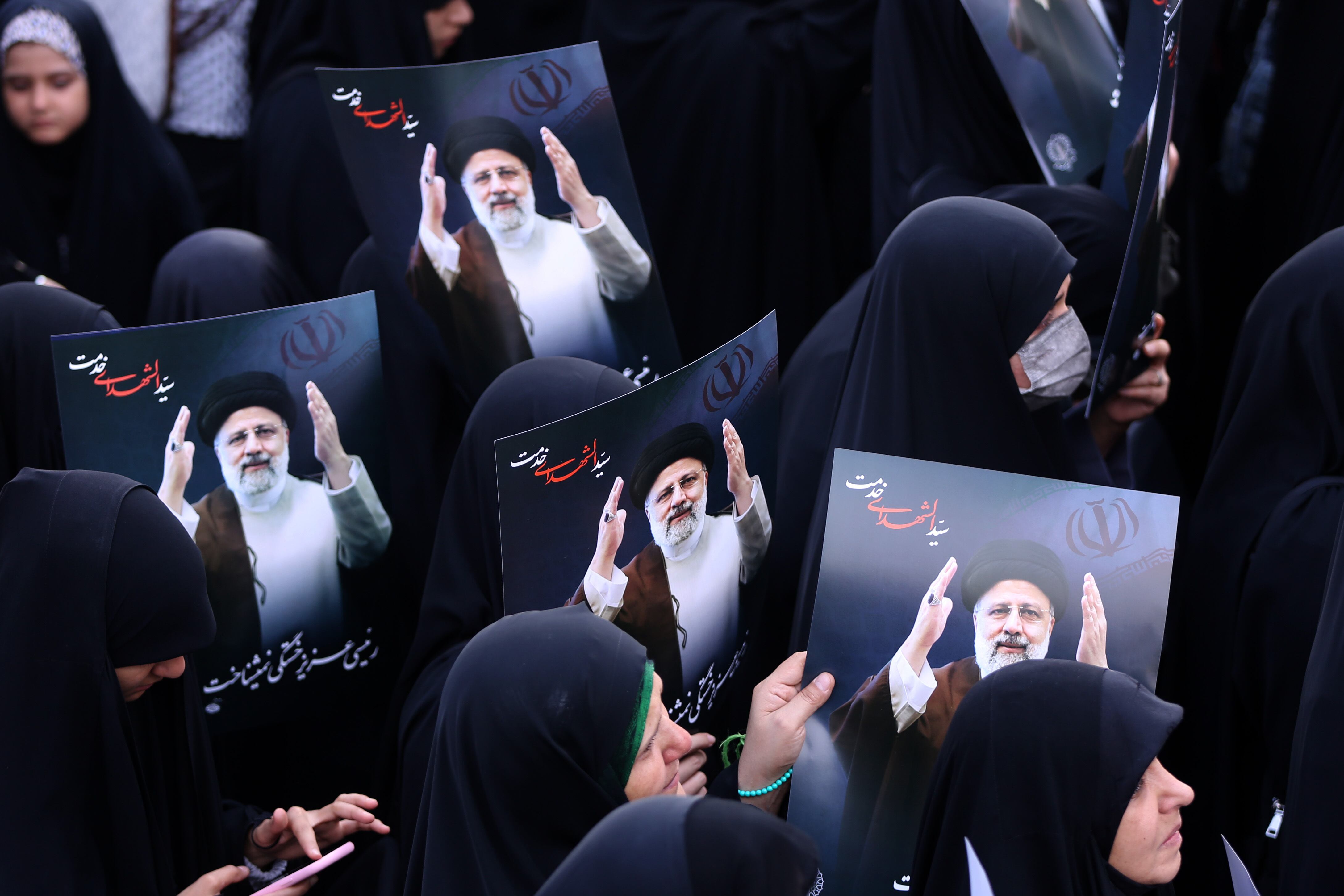 TEHRAN, IRAN - MAY 20: People holding photos gathering at Valiasr Square mourn the death of Iranian President Ebrahim Raisi, Foreign Minister Hussein Amir Abdollahian and other Iranian officials in a helicopter crash on Sunday in Iran, during a ceremony in Tehran on May 20, 2024. (Photo by Fatemeh Bahrami/Anadolu via Getty Images)