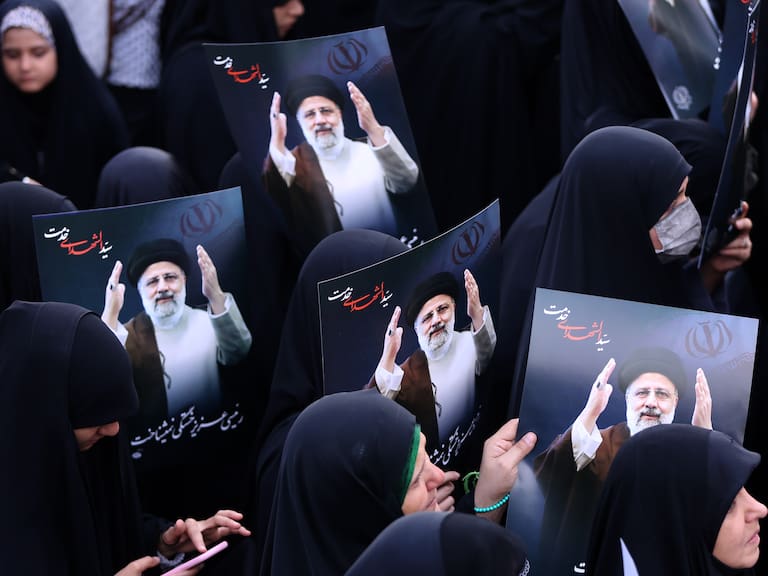 TEHRAN, IRAN - MAY 20: People holding photos gathering at Valiasr Square mourn the death of Iranian President Ebrahim Raisi, Foreign Minister Hussein Amir Abdollahian and other Iranian officials in a helicopter crash on Sunday in Iran, during a ceremony in Tehran on May 20, 2024. (Photo by Fatemeh Bahrami/Anadolu via Getty Images)