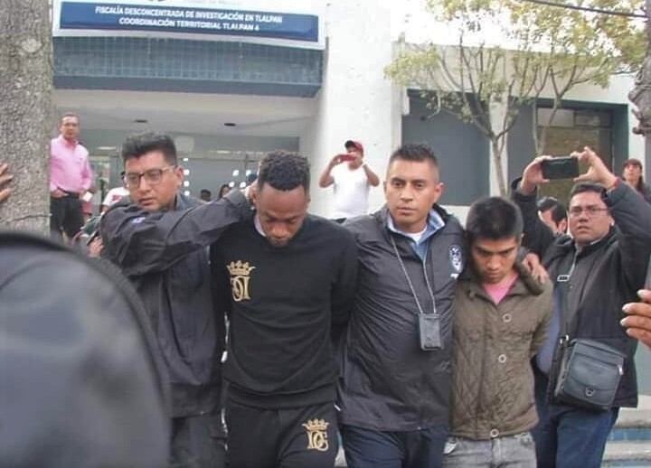 Los funcionarios policiales conducen al detenido futbolista Renato Ibarra
