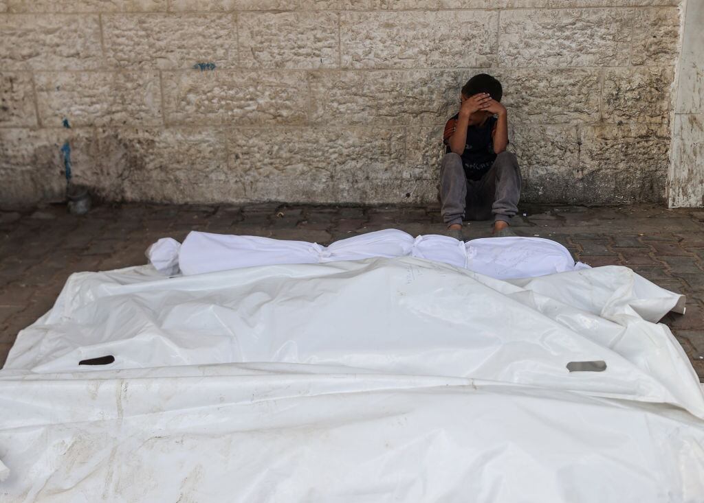 Una persona llora la muerte de sus familiares en uno de los ataques de Israel contra un recinto con refugiados en la Franja de Gaza en Palestina.