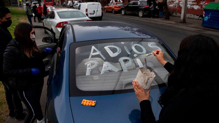 A woman writes "Goodbye daddy" on the car window while waiting to receive his coffin, outside the San Jose Public Hospital morgue, in Santiago, on June 22, 2020 amid the new coronavirus pandemic. - Chile nearly doubled its reported coronavirus death toll Saturday to more than 7,000 under a new tallying method that includes probable fatalities from COVID-19. (Photo by MARTIN BERNETTI / AFP) (Photo by MARTIN BERNETTI/AFP via Getty Images)