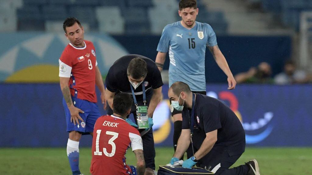 Chile's Erick Pulgar receives medical assistance during the Conmebol Copa America 2021 football tournament group phase match between Uruguay and Chile at the Pantanal Arena in Cuiaba, Brazil, on June 21, 2021. (Photo by DOUGLAS MAGNO / AFP) (Photo by DOUGLAS MAGNO/AFP via Getty Images)