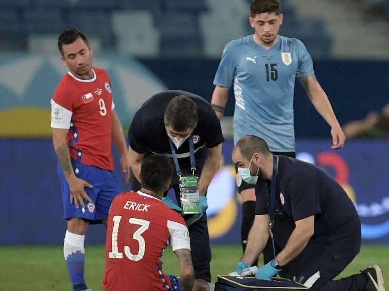Chile&#039;s Erick Pulgar receives medical assistance during the Conmebol Copa America 2021 football tournament group phase match between Uruguay and Chile at the Pantanal Arena in Cuiaba, Brazil, on June 21, 2021. (Photo by DOUGLAS MAGNO / AFP) (Photo by DOUGLAS MAGNO/AFP via Getty Images)