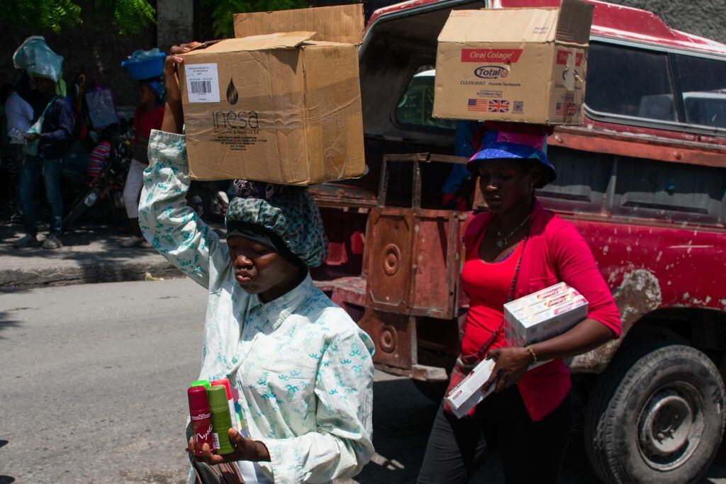 Personas llevan sus compras en unas cajas en la ciudad de Puerto Príncipe en Haití.