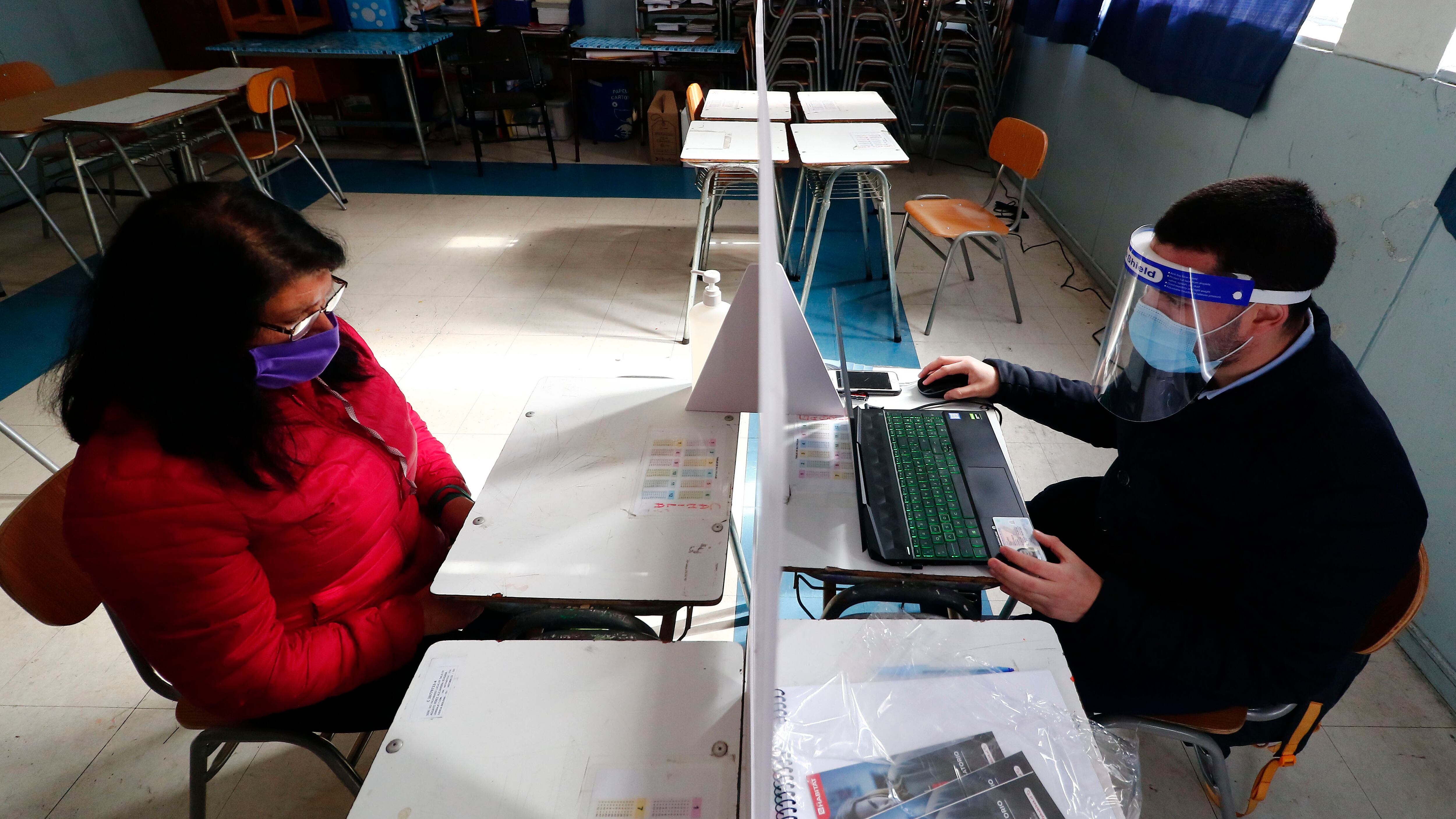 04 DE AGOSTO DE 2020/VALPARAISOUn funcionario de AFP Habitat entrega informacion a una mujer, luego que el Liceo Matilde Brandau fuera habilitado por la autoridad como local de informacion e inscripcion para el proceso de retiro de parte de los fondos de pensiones.
FOTO: LEONARDO RUBILAR CHANDIA/AGENCIAUNO