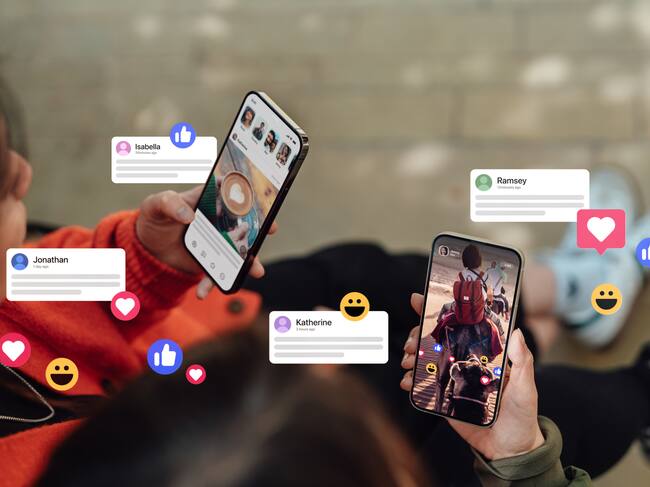 Two female hands holding their smartphones, connecting with social media, leaving comments, sending messages and sharing photos. Technology connecting people.