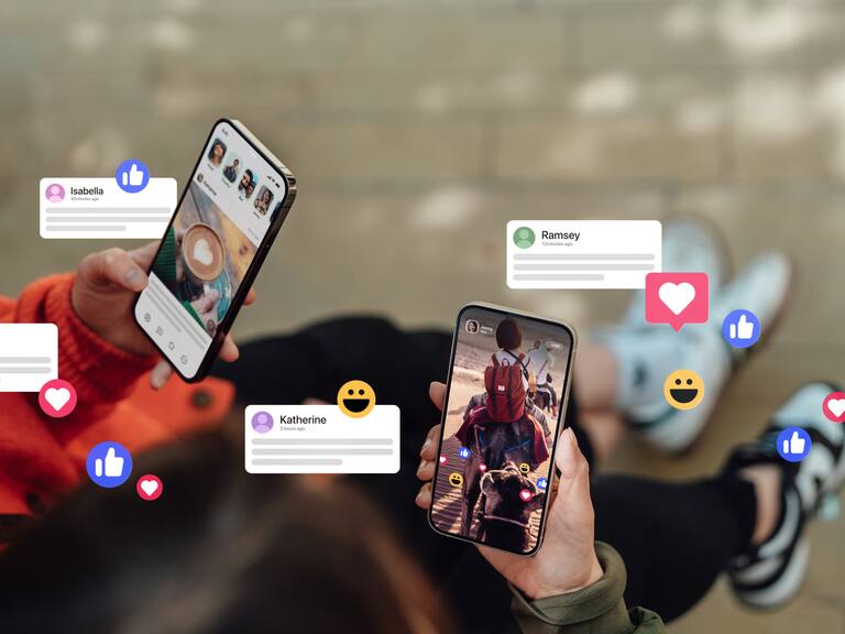 Two female hands holding their smartphones, connecting with social media, leaving comments, sending messages and sharing photos. Technology connecting people.