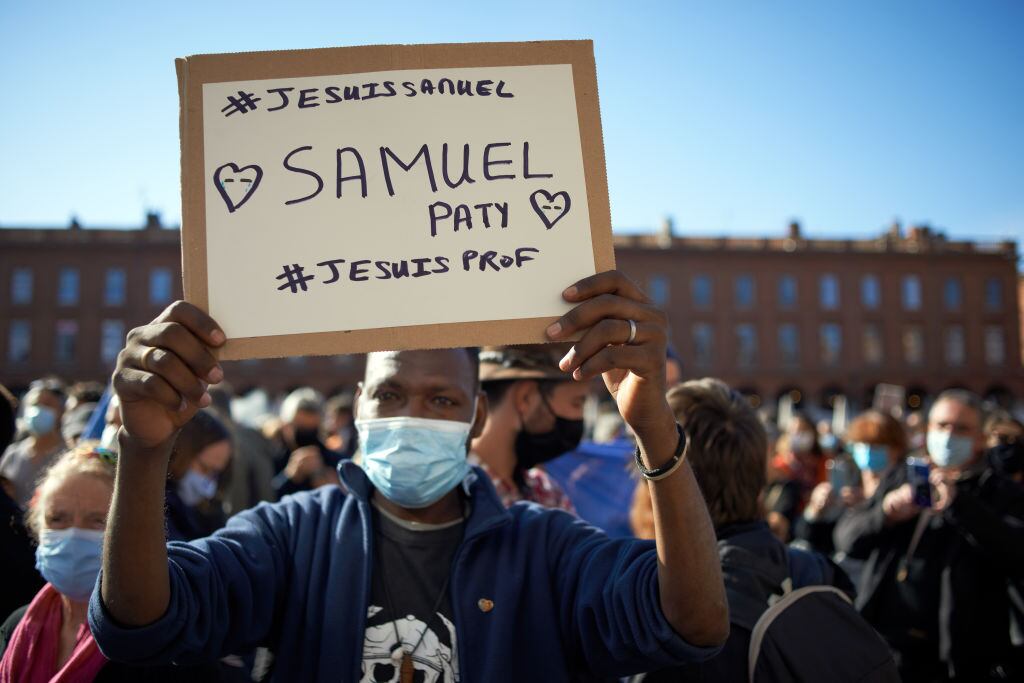 Un hombre sostiene un cartel que recuerda a Samuel Paty