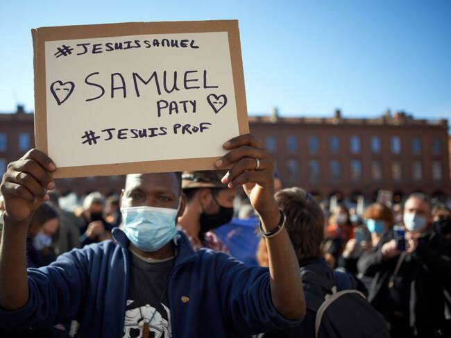 Un hombre sostiene un cartel que recuerda a Samuel Paty