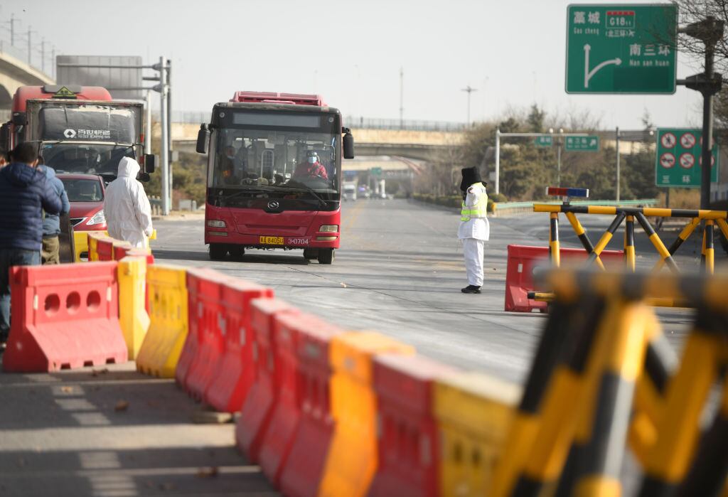 Funcionarios revisan el paso de buses por el Covid-19 en China