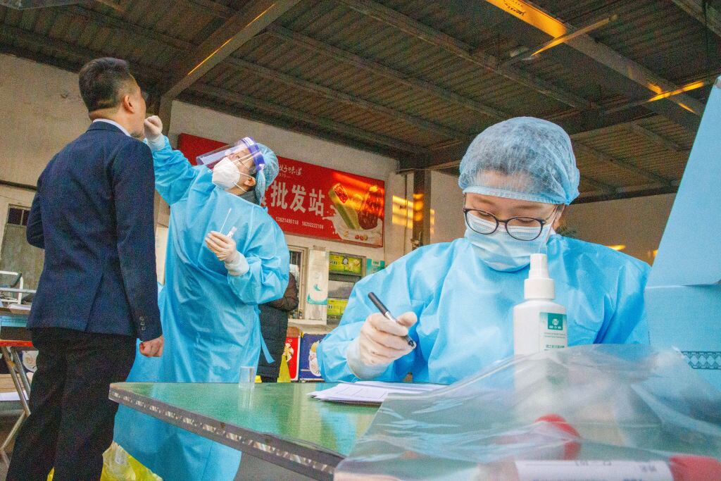 Trabajadores de la salud realizan exámenes del Covid-19 en Tianjin