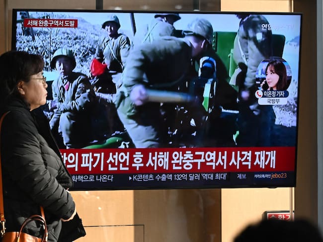 Mujer camina ante una televisión en Seúl, donde se informa del lanzamiento de proyectiles realizado por Corea del Norte ante las costas surcoreanas.