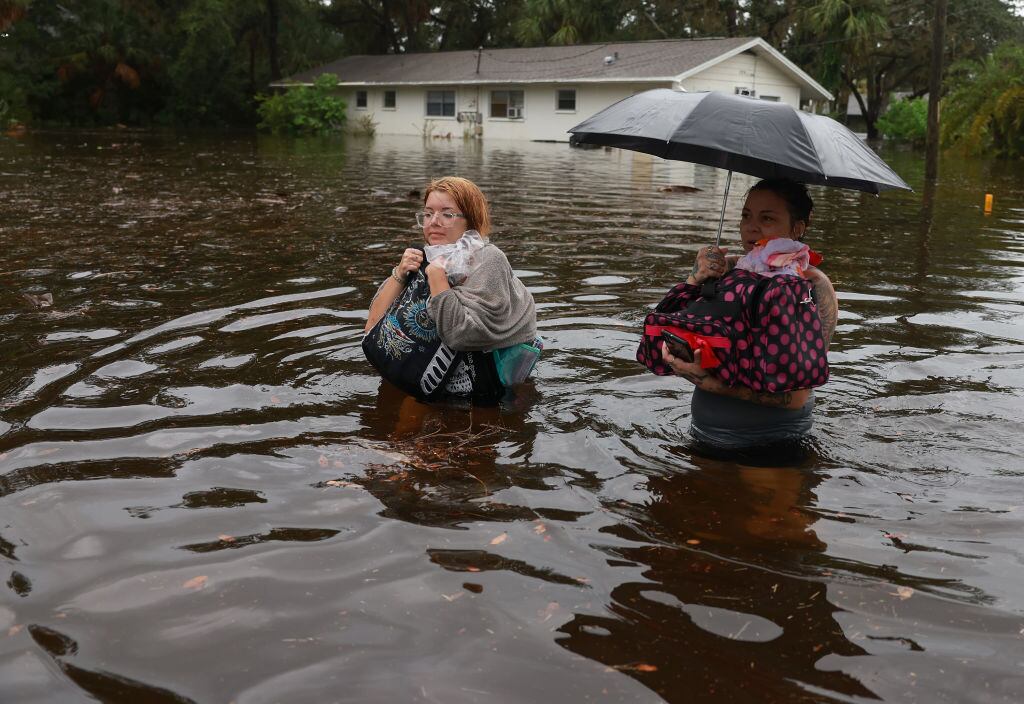 Mujeres intentan salir de las calles con agua en Tarpon Springs de Florida