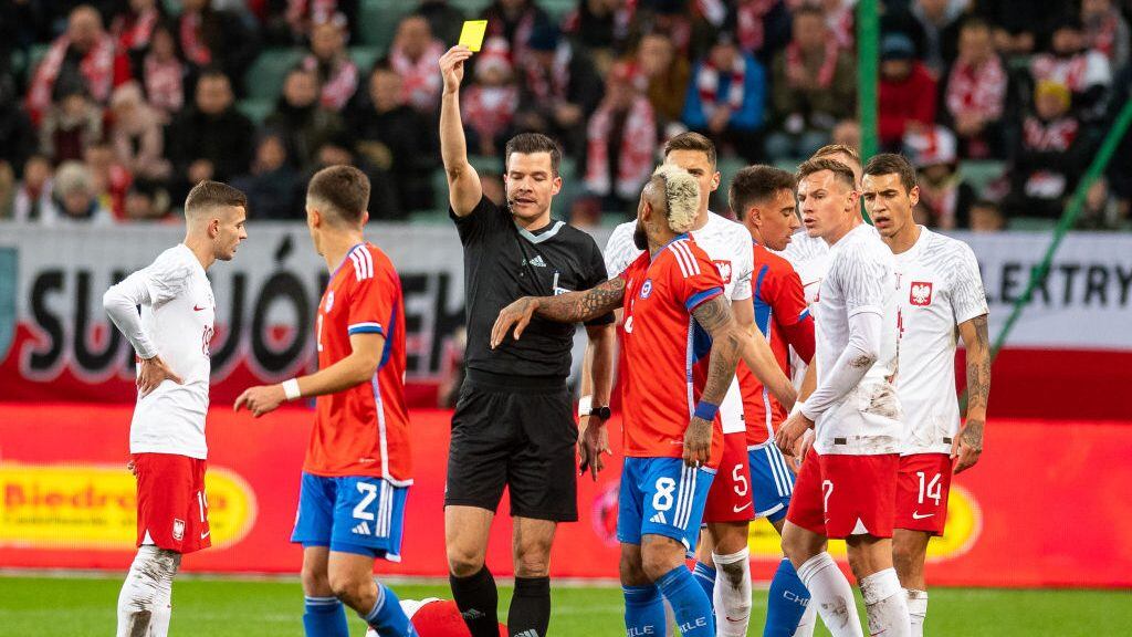 WARSAW, POLAND - NOVEMBER 16: referee Harm Osmers show Eugenio Mena of Chile the yellow card during the friendly match between Poland v Chile on November 16, 2022 in Warsaw, Poland. (Photo by Mateusz Slodkowski/DeFodi Images via Getty Images)