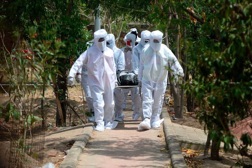 Voluntarios llevan a una víctima del Covid-19 en India