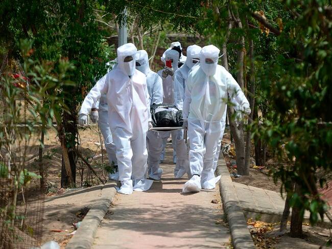 Voluntarios llevan a una víctima del Covid-19 en India