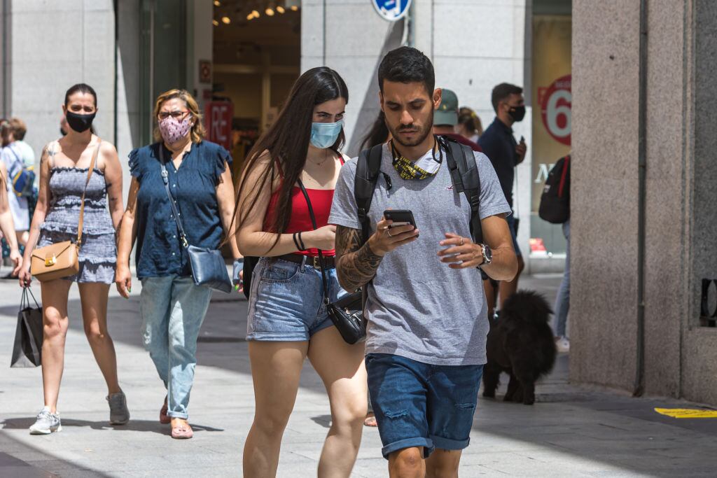 Las personas caminan por calles comerciales en Madrid