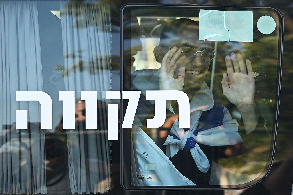 RAMAT GAN, ISRAEL - OCTOBER 13: Gaza hostage Maxim Herkin wavesMaxim Herkin as he arrives at Chaim Sheba Medical Center at Tel HaShomer on October 13, 2025 in Ramat Gan, Israel. The ceasefire deal between Israel and Hamas has brought an end to the two years of war that followed the attacks of Oct. 7, 2023. A condition of the deal was the immediate return of 48 hostages held in Gaza, around 20 of whom were believed to be alive. (Photo by Alexi J. Rosenfeld/Getty Images)