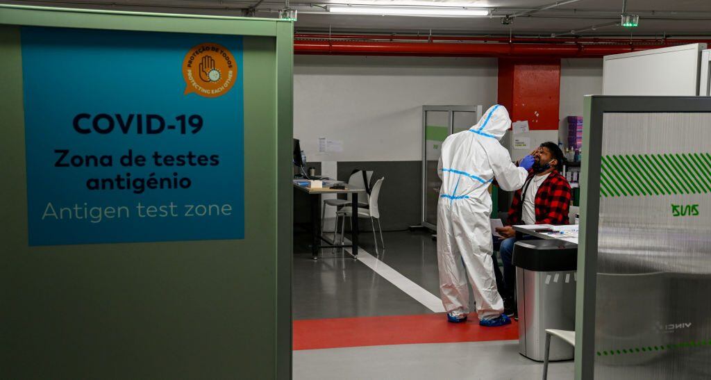 LISBON, PORTUGAL - JUNE 07: A health technician wearing full protective gear takes a nasal swab for a PCR COVID-19 test of a traveler at Synlab post in Parking lot 1 of Humberto Delgado International Airport a day before the country becomes no longer on the UK's green list, imposing a mandatory ten-day quarantine to British residents returning home, during the COVID-19 Coronavirus pandemic on June 07, 2021 in Lisbon, Portugal. After the announcement of the British decision last June 03, thousands of British tourists interrupted their vacations and headed home. According to the president of the Algarve Tourist Board on June 05 alone, around 10,000 British tourists have departed Faro, in Algarve. (Photo by Horacio Villalobos#Corbis/Corbis via Getty Images)