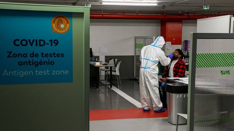 LISBON, PORTUGAL - JUNE 07: A health technician wearing full protective gear takes a nasal swab for a PCR COVID-19 test of a traveler at Synlab post in Parking lot 1 of Humberto Delgado International Airport a day before the country becomes no longer on the UK's green list, imposing a mandatory ten-day quarantine to British residents returning home, during the COVID-19 Coronavirus pandemic on June 07, 2021 in Lisbon, Portugal. After the announcement of the British decision last June 03, thousands of British tourists interrupted their vacations and headed home. According to the president of the Algarve Tourist Board on June 05 alone, around 10,000 British tourists have departed Faro, in Algarve. (Photo by Horacio Villalobos#Corbis/Corbis via Getty Images)