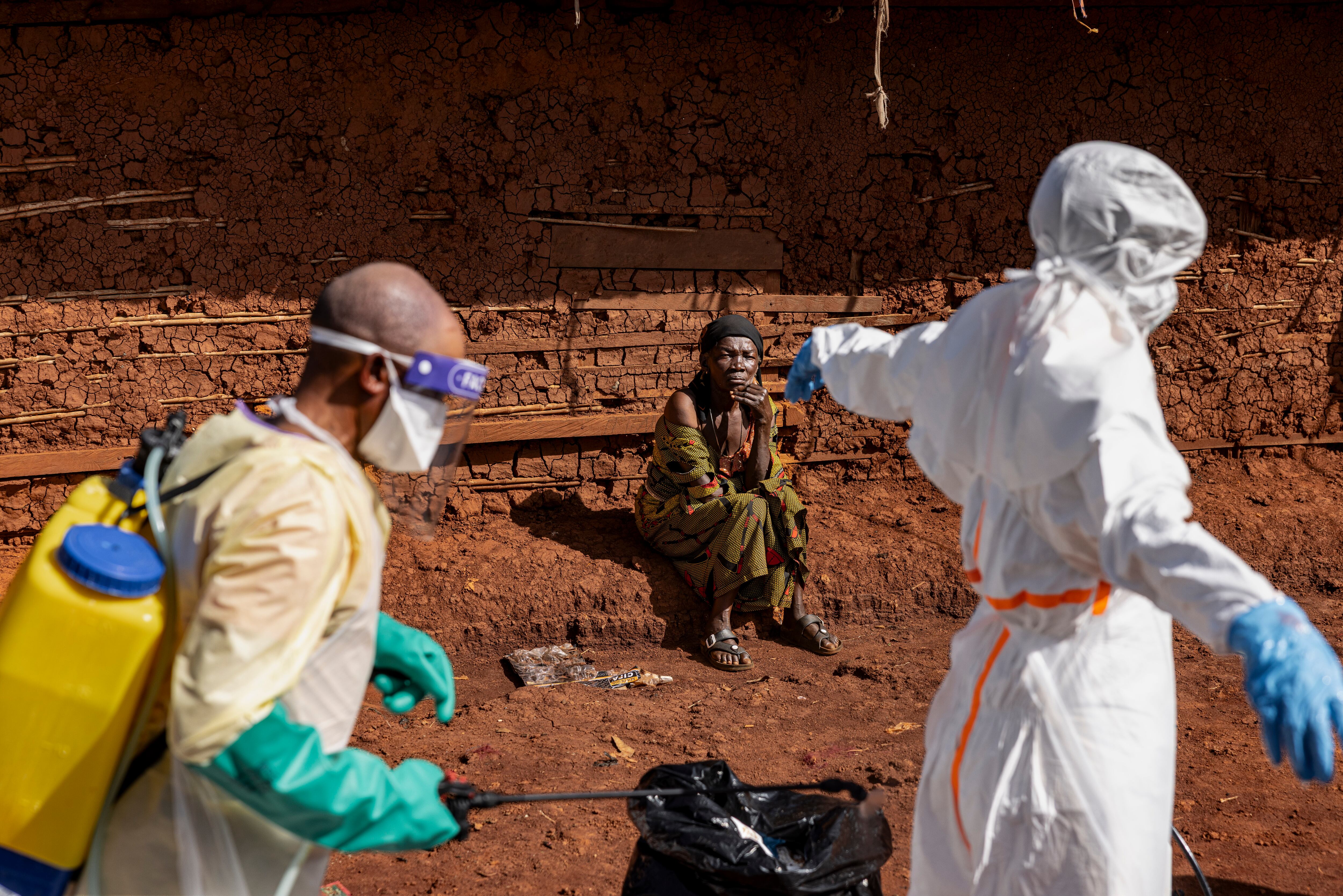 MONGBWALU, DEMOCRATIC REPUBLIC OF CONGO - MAY 24: The mother of the late Saidi Mumbere watches as health workers carry out Ebola response activities in the community of Mongbwaluon May 24, 2026 in Mongbwalu, Ituri Province, Democratic Republic of Congo. The World Health Organization (WHO) has declared the Ebola outbreak in the Democratic Republic of Congo (DRC) and Uganda a "public health emergency of international concern," as the death toll and number of confirmed cases continue to rise. The current epidemic is caused by the Bundibugyo virus, one of several Orthoebolaviruses that can cause Ebola disease, and for which there are no approved vaccines. The highest number of cases have been reported in Congo's eastern Ituri province, bordering Uganda. Global health officials have expressed grave concern over the capacity to contain the outbreak in a region already facing a humanitarian crisis, with highly mobile populations displaced by conflict and economic factors. (Photo by Michel Lunanga/Getty Images)