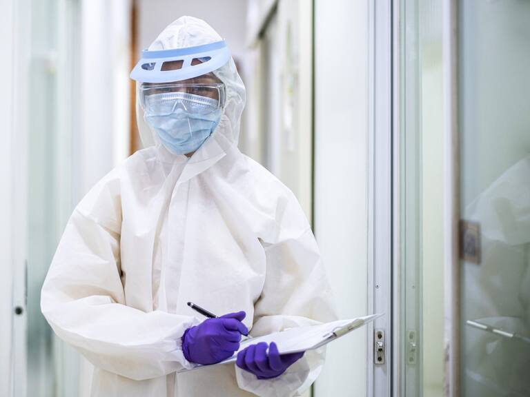 Asian doctor holding checking coronavirus or covid-19 infected patient name list sheet in quarantine area in hospital