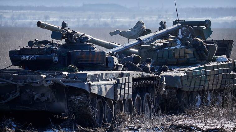 VUGLEGIRSK , UKRAINE - FEBRUARY 18: Pro-Russian rebels tow a seized Ukrainian tank (R) on February 18, 2015, near Vuglegirsk, Ukraine. Ukrainian troops have been forced to retreat from Debaltseve following continued fighting as rebels advance on the town in spite of the recent ceasefire agreement. (Photo by Pierre Crom/Getty Images)