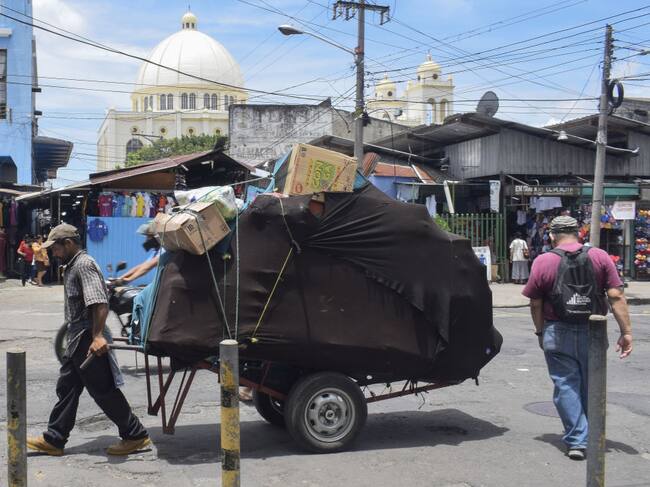 Hombre traslada una carreta en medio de cesantes en El Salvador