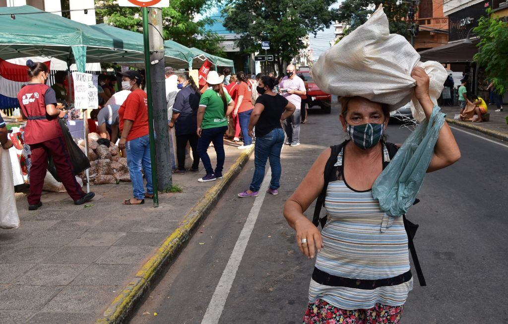 Una mujer lleva su producción diaria sobre su cabeza en Asunción