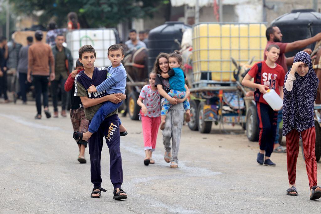 Niños palestinos caminan por la Franja de Gaza buscando el agua