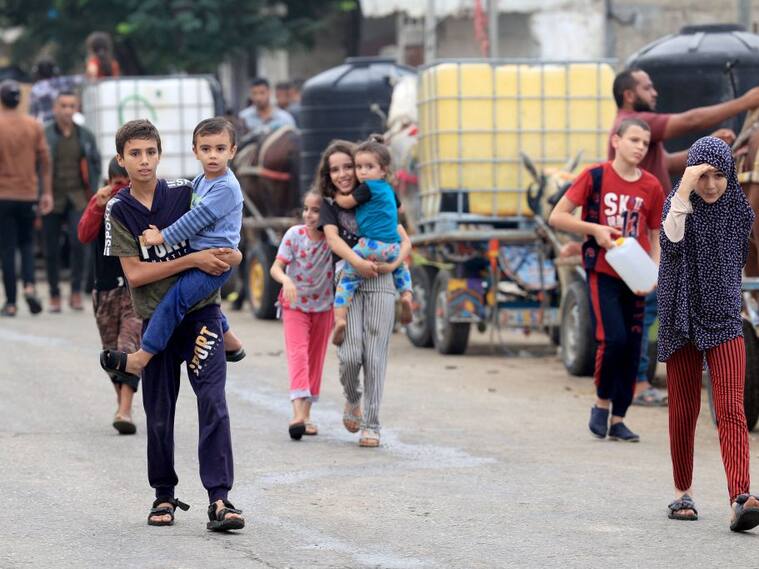 Niños palestinos caminan por la Franja de Gaza buscando el agua