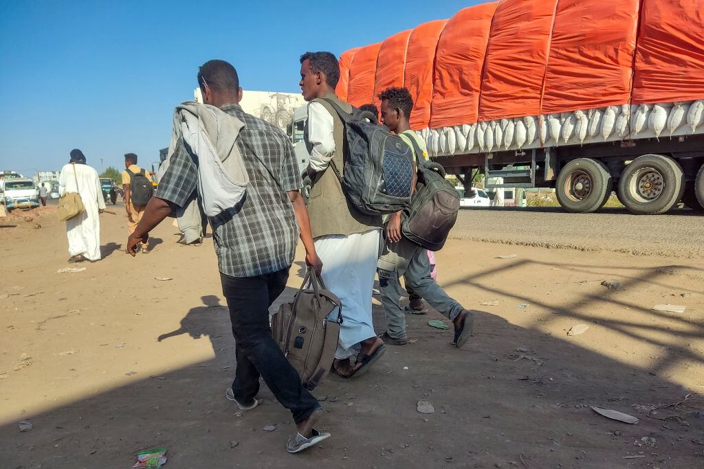 Personas desplazadas caminan al costado de una ruta para escapar de la guerra que se vive en Sudán de África.