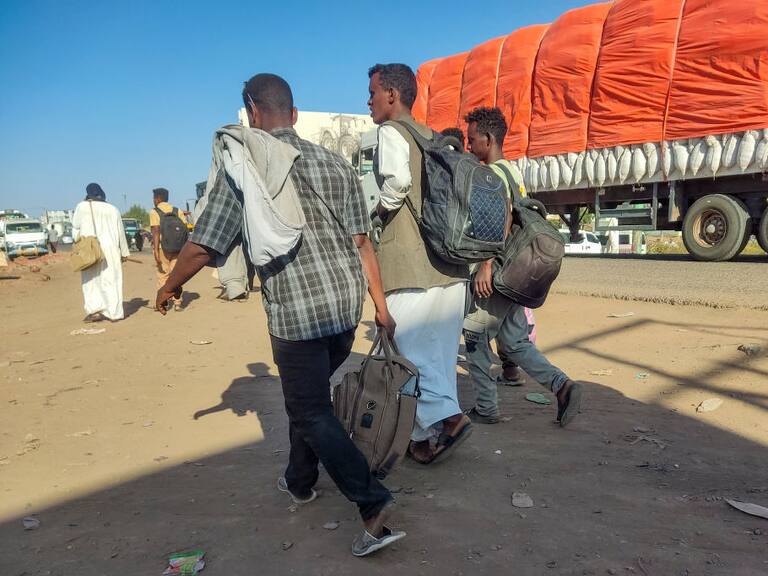 Personas desplazadas caminan al costado de una ruta para escapar de la guerra que se vive en Sudán de África.