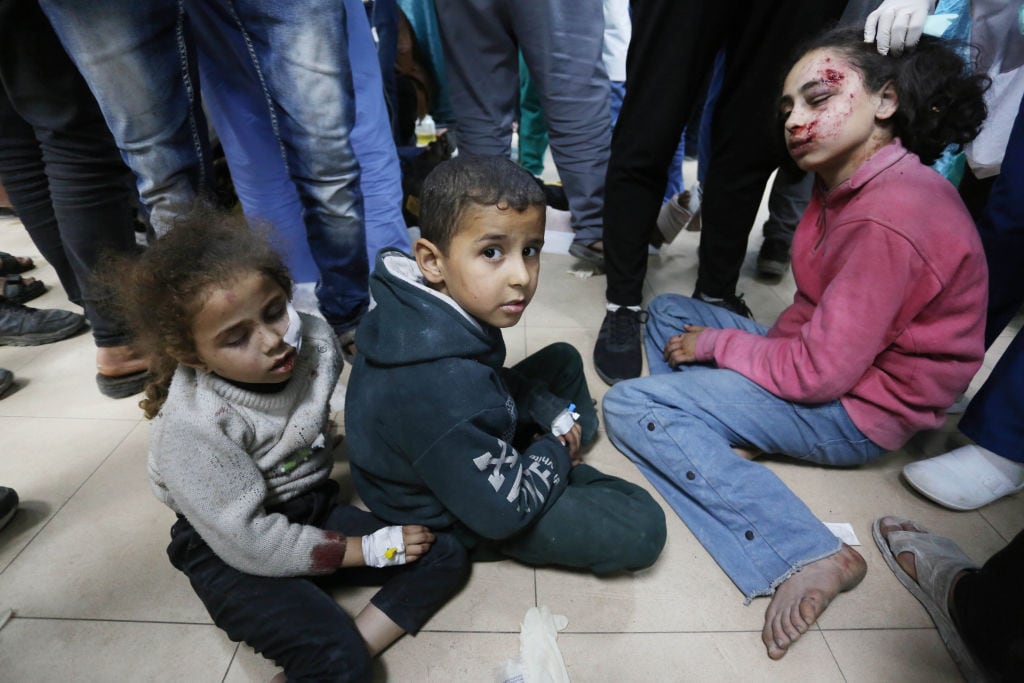 Tres niños heridos esperan atención en un recinto médico en la Franja de Gaza, luego de uno de los bombardeos de Israel contra el enclave palestino.