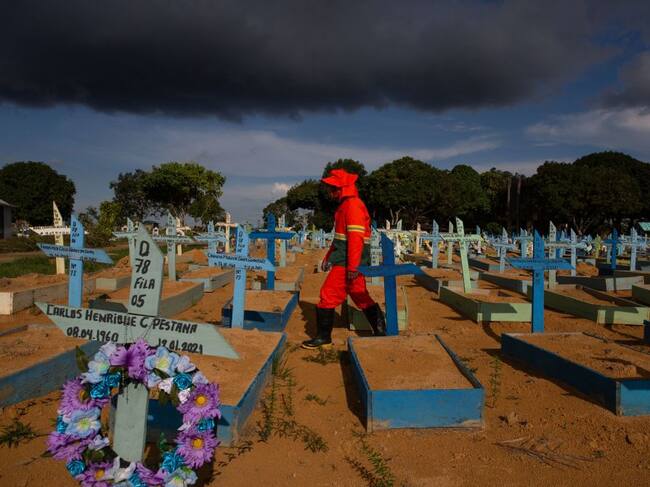 El trabajador de un cementerio camina entre las tumbas de víctimas del Covid-19 en Brasil