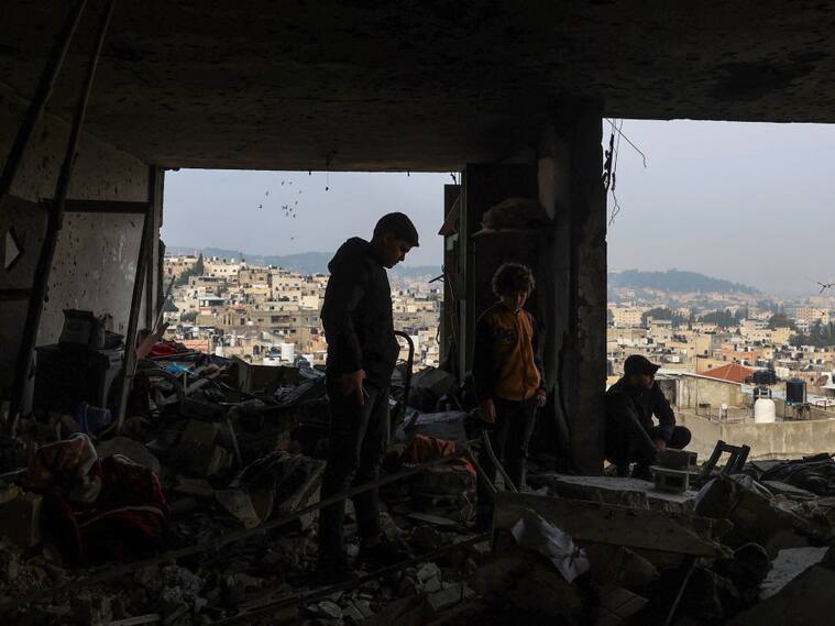 Familias observan la destrucción de sus viviendas por los ataques militares de Israel en contra de la Franja de Gaza en Palestina