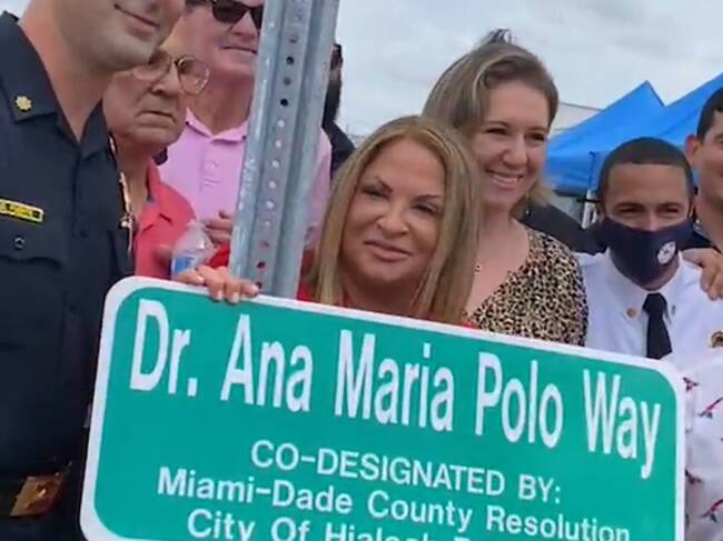Ana María Polo posando con los ciudadanos de Hialeah y el letrero de su calle.