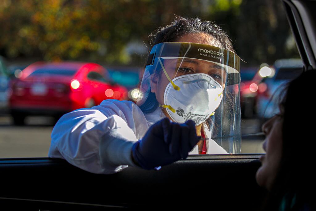 Trabajadora de la salud realiza un examen de PCR en San Bernardino