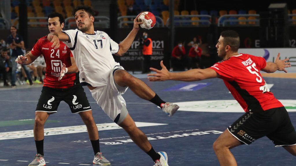 Chile's right back Rodrigo Salinas (C) jumps to shoot past Egypt's pivot Ibrahim El Masry (L) and Egypt's right back Mohsen Ramadan Mahmoud during the opening match of the 2021 World Men's Handball Championship between Group G teams Egypt and Chile at the Cairo Stadium Sports Hall in the Egyptian capital on January 13, 2021. (Photo by MOHAMED ABD EL GHANY / POOL / AFP) (Photo by MOHAMED ABD EL GHANY/POOL/AFP via Getty Images)