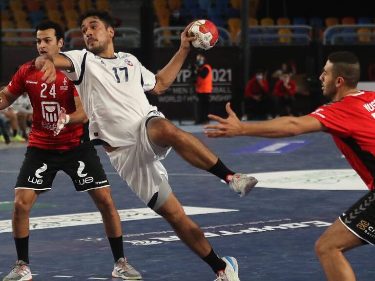 Chile's right back Rodrigo Salinas (C) jumps to shoot past Egypt's pivot Ibrahim El Masry (L) and Egypt's right back Mohsen Ramadan Mahmoud during the opening match of the 2021 World Men's Handball Championship between Group G teams Egypt and Chile at the Cairo Stadium Sports Hall in the Egyptian capital on January 13, 2021. (Photo by MOHAMED ABD EL GHANY / POOL / AFP) (Photo by MOHAMED ABD EL GHANY/POOL/AFP via Getty Images)
