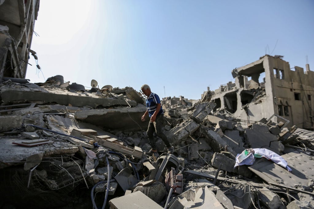 Hombre camina entre los escombros que dejan los ataques de Israel en Gaza