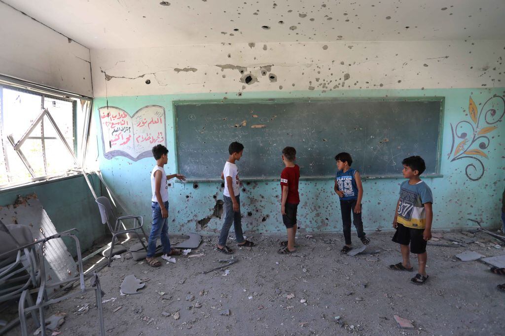 Niños palestinos observan la destrucción de su escuela tras los ataques sobre Gaza