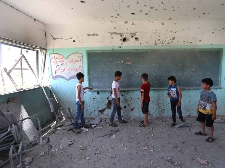 Niños palestinos observan la destrucción de su escuela tras los ataques sobre Gaza