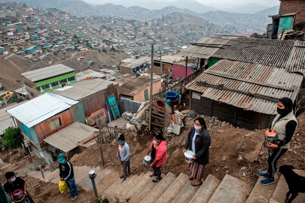 Mujeres esperan la entrega de comida en un barrio de Lima