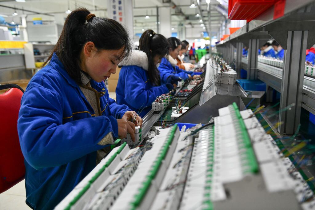 Trabajadoras ayudan en la elaboración de componentes en una empresa eléctrica de Fuyang en China.
