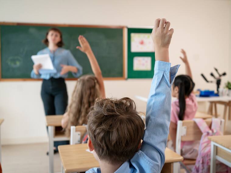 Caucasian young woman teacher teaching student in classroom at school. Attractive beautiful female instructor master explain and educate children with fun activity at preschool nursery kindergarten.