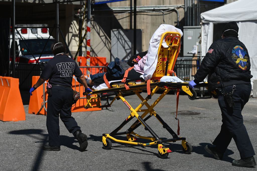 Un grupo de paramédicos  conducen a un paciente contagiado del nuevo coronavirus en Brooklyn