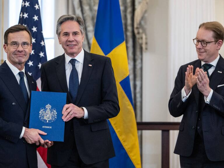 US Secretary of State Antony Blinken receives the NATO ratification documents from Swedish Prime Minister Ulf Kristersson, as Swedish Foreign Minister Tobias Billstrom applauds, during a ceremony at the US State Department, as Sweden formally joins the North Atlantic alliance, in Washington, DC, on March 7, 2024. Kristersson hailed his country's entry into NATO as a "victory for freedom," as it turned the page on two centuries of non-alignment following Russia's invasion of Ukraine. The accession "is a victory for freedom today. Sweden has made a free, democratic, sovereign and united choice to join NATO," he said at the ceremony. (Photo by ANDREW CABALLERO-REYNOLDS / AFP) (Photo by ANDREW CABALLERO-REYNOLDS/AFP via Getty Images)