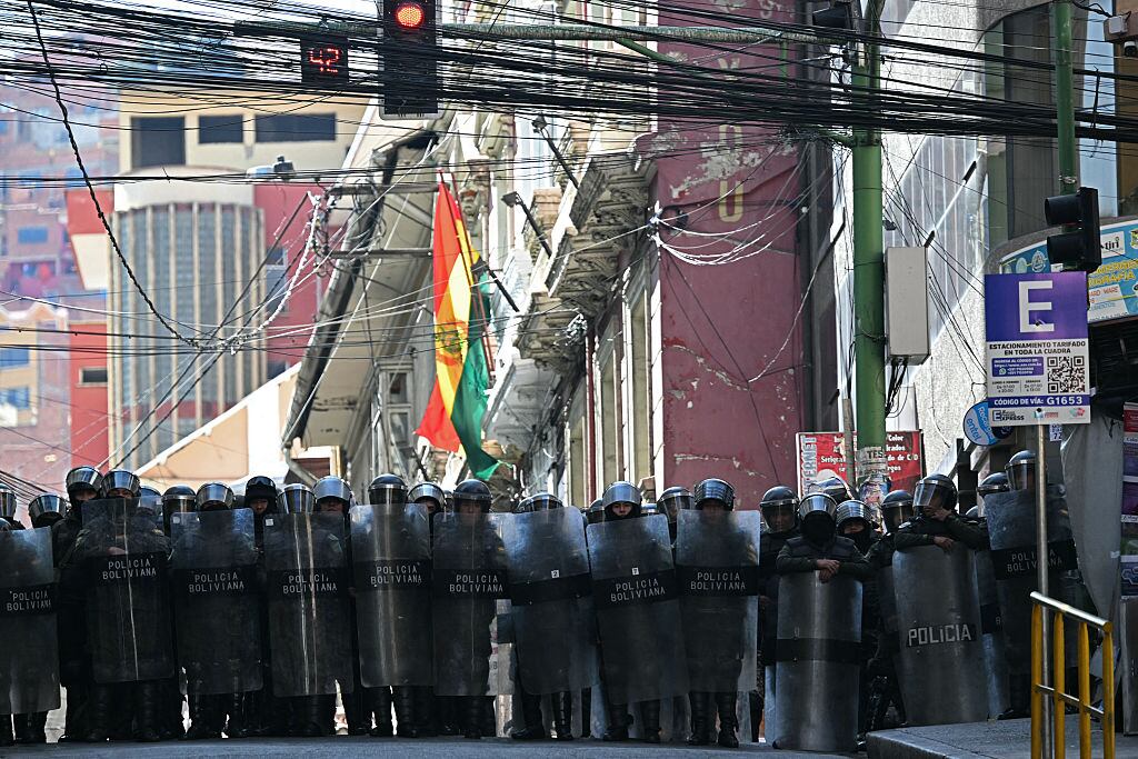 Riot police stand guard during a protest demanding the resignation of Bolivian President Rodrigo Paz, in La Paz, on May 18, 2026. Bolivians have taken to the streets for the past two weeks, blocking roads into La Paz and disrupting deliveries of food, medicine and other goods to the seat of government, while demanding higher wages, economic relief and the resignation of centre-right President Rodrigo Paz amid a severe economic crisis. (Photo by AIZAR RALDES / AFP via Getty Images)
